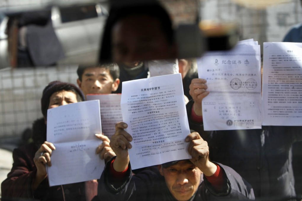 Petitioners kneel before a car, blocking its way, as they beg to display their letters near a government office supposed to receive complaints in Beijing. Chinese take their grievances to the leadership as a last resort. Photo: AP