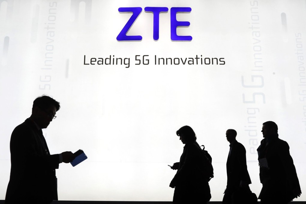 Attendees pass by the ZTE Corp. stand at the Mobile World Congress (MWC) in Barcelona. Photo: Bloomberg