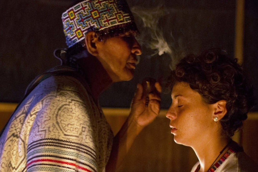 Shaman Pablo Flores blows tobacco smoke at tourist Pamela Moronci during an ayahuasca session in Nuevo Egipto, a remote village in the Peruvian Amazon. Photo: AP