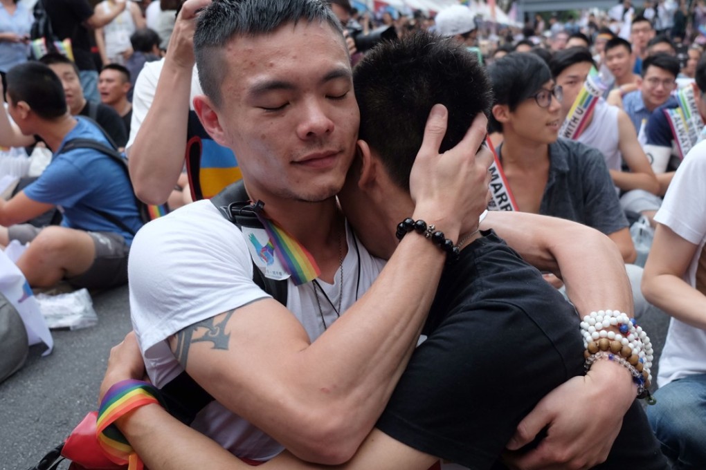 Same-sex activists hug outside parliament in Taipei on May 24, 2017 as they celebrate the landmark decision paving the way for the island to become the first place in Asia to legalise gay marriage. Photo: AFP