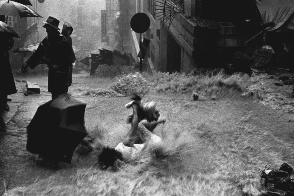 A woman being swept down the junction of Third and Centre Street in Sai Ying Pun as the heavy rainstorm spread across the city on June 12, 1966. Photo: Chan Kiu