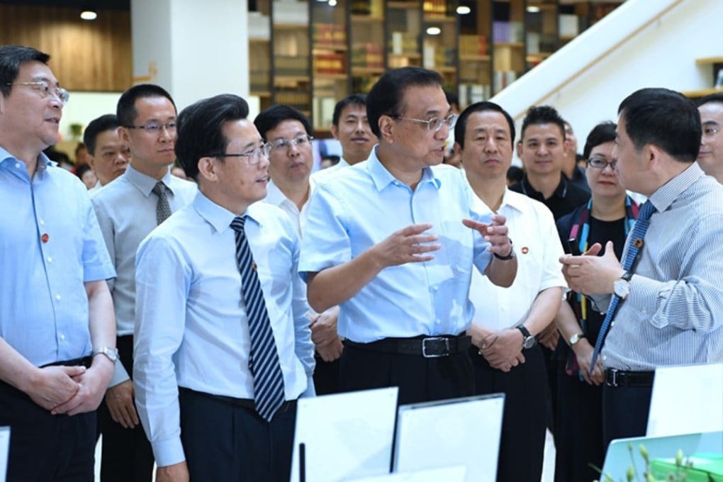 Chinese Premier Li Keqiang (centre) chats to workers at Sany Group’s factory in Changsha on Tuesday. Photo: Handout