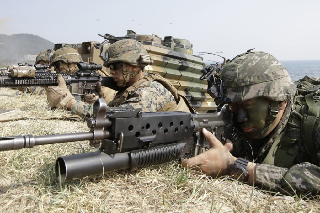 Marines of South Korea and the US aim their weapons near amphibious assault vehicles during US-South Korea joint landing military exercises. Photo: AP