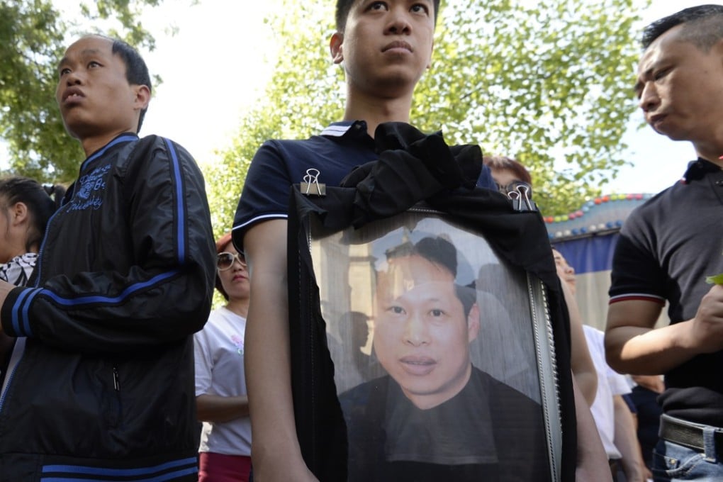 Relatives hold a portrait of Zhang Chaolin during a tribute ceremony outside city hall in Aubervilliers, northeast Paris, on August 14, 2016. Photo: AFP