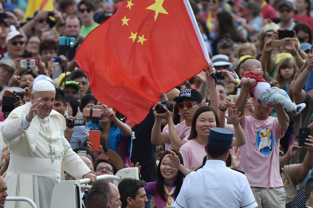 Pope Francis waves to the crowd as the Popemobile nears onlookers holding a Chinese flag in St Peter's Square in June 2016. Photo: AFP
