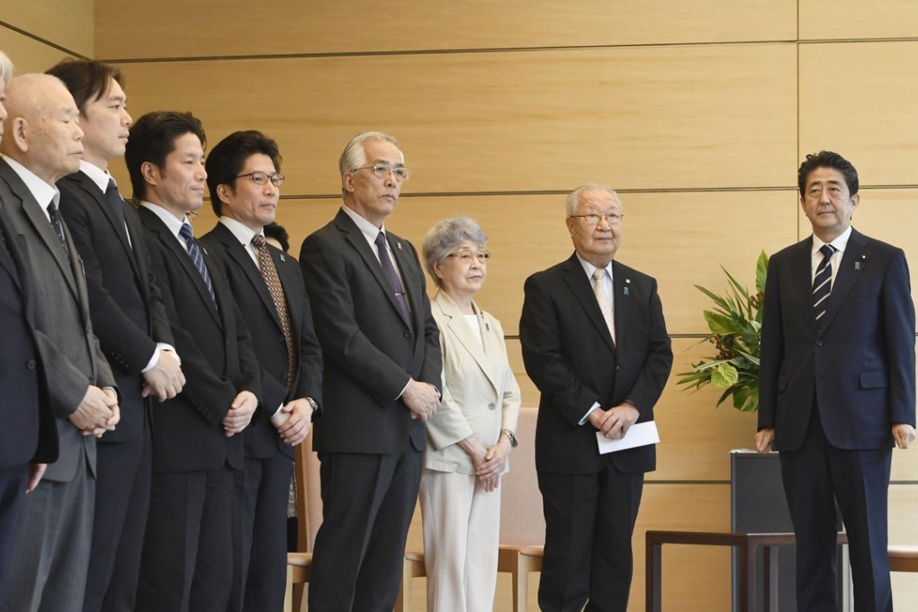 Japanese Prime Minister Shinzo Abe, right, meeting on Thursday in Tokyo with a group representing families of Japanese nationals abducted by North Korea. Photo: Kyodo