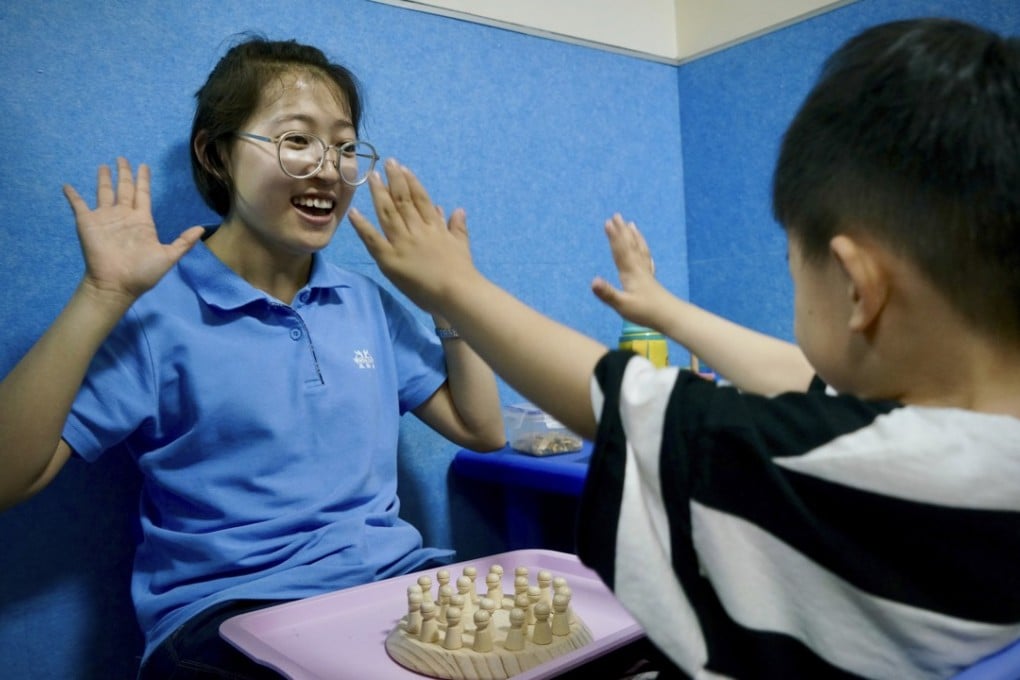 A teacher plays a game with a young autistic boy at the Wucailu centre in Beijing. Photo: Tom Wang