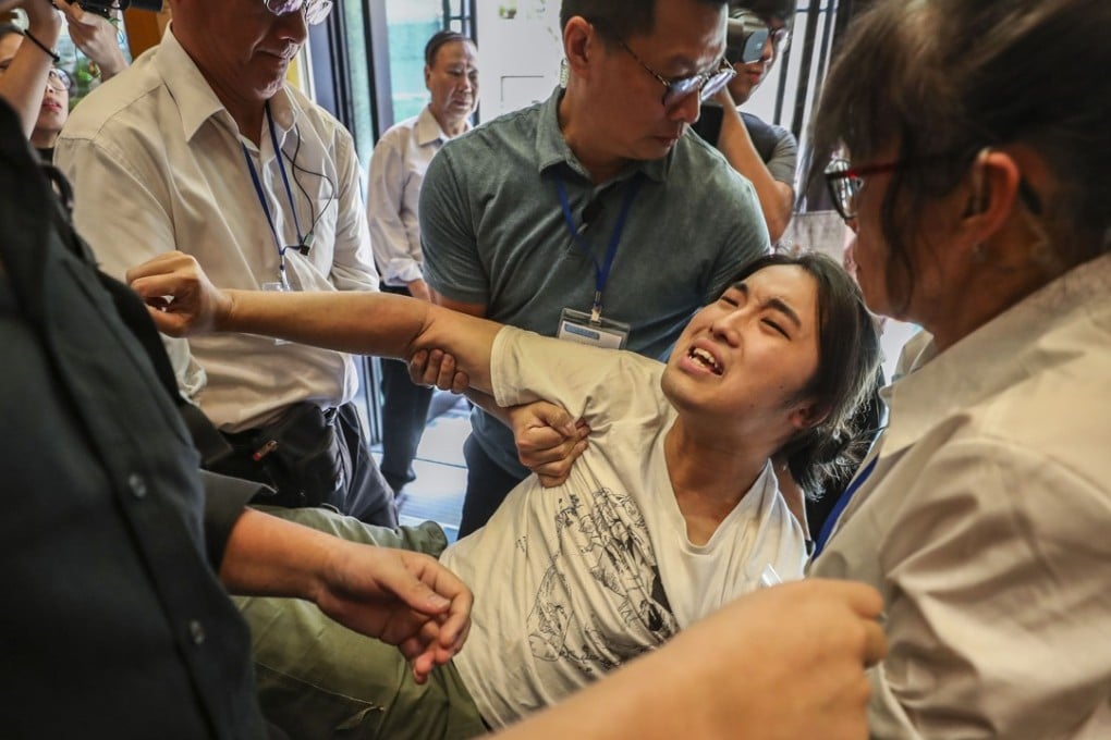 An activist is carried away from the land supply forum held at the Leighton Hill Community Hall in Happy Valley. Photo: Winson Wong