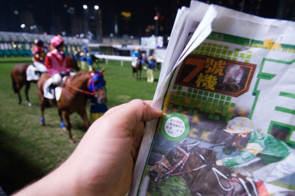 A punter checks the horse form at Happy Valley racecourse, in Hong Kong. Picture: Alamy