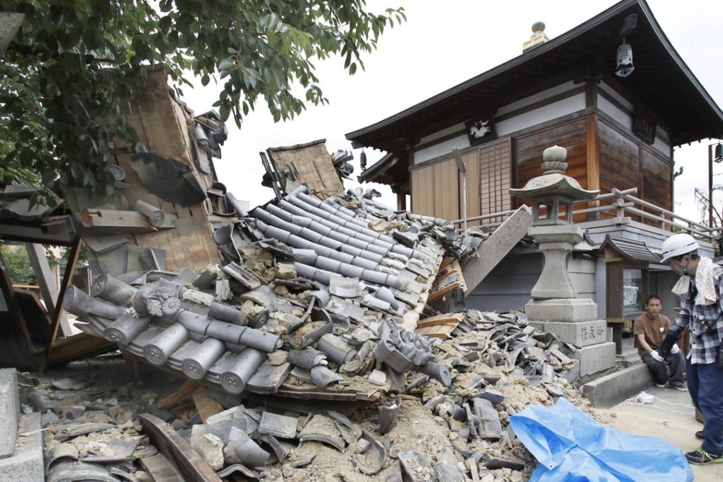 The gate of Myotoku-ji temple collapses after an earthquake hit Ibaraki City, Osaka, western Japan, Monday, June 18, 2018. A strong earthquake knocked over walls and set off scattered fires around metropolitan Osaka on Monday morning. (Yosuke Mizuno/Kyodo News via AP)