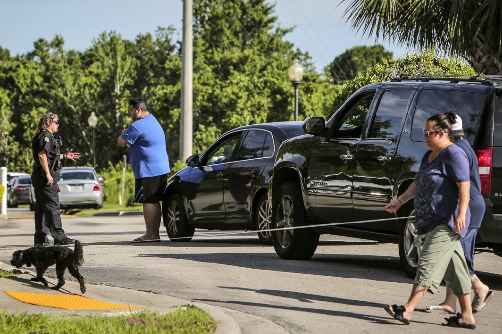 An Orlando police officer checks the identification of residents trying to enter the Westbrook Apartments on Tuesday. Photo: Orlando Sentinel/TNS