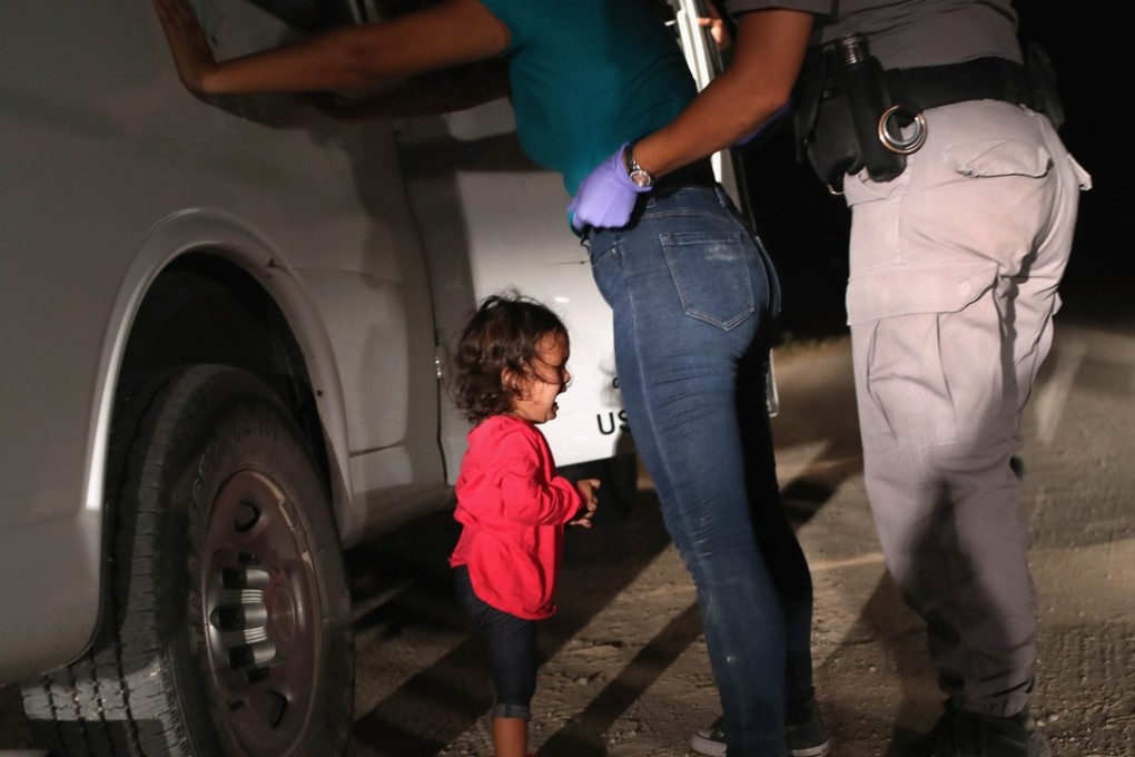A two-year-old cries as her mother, a Honduran asylum seeker, is searched and detained near the US-Mexico border on Tuesday near McAllen, Texas. Photo: Getty Images/Agence France-Presse