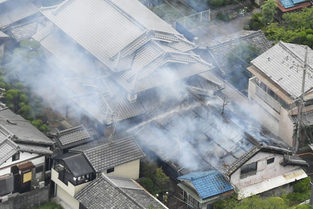 Firefighters respond to a blaze at a house north of Osaka city after the quake. Photo: AP