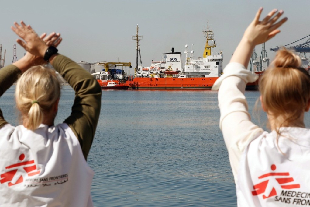 Staff of the relief organisation Medecins Sans Frontieres wave to the migrant rescue ship Aquarius, as it arrives at port in Valencia, Spain, on June 17. Both Malta and Italy refused the ship safe harbour. Photo: EPA-EFE