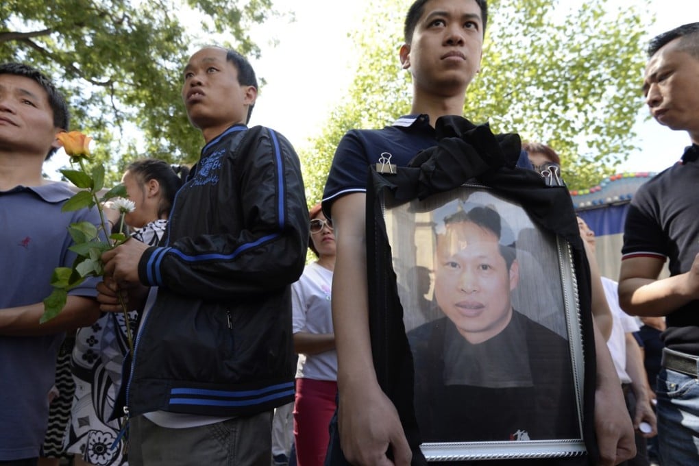 Family members hold the portrait of Zhang Chaolin during a tribute ceremony outside the city hall in Aubervilliers, a suburb of Paris, France, on August 14, 2016. Photo: AFP