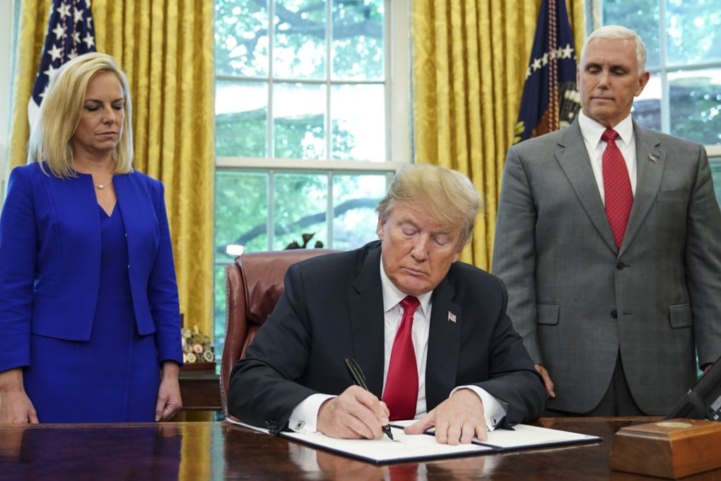 US President Donald Trump signing an executive order on immigration on Wednesday as Homeland Security Secretary Kirstjen Nielsen and Vice-President Mike Pence look on. Photo: AFP