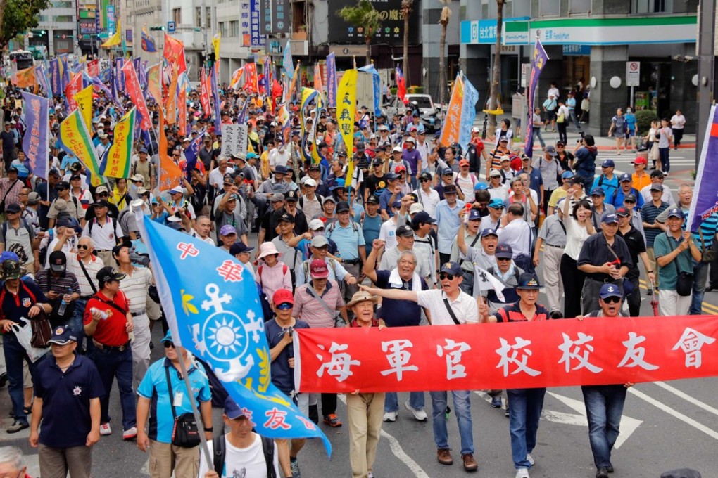 Military veterans march near the parliament building in Taipei in protest over the pension reform bill on Tuesday. Photo: AFP