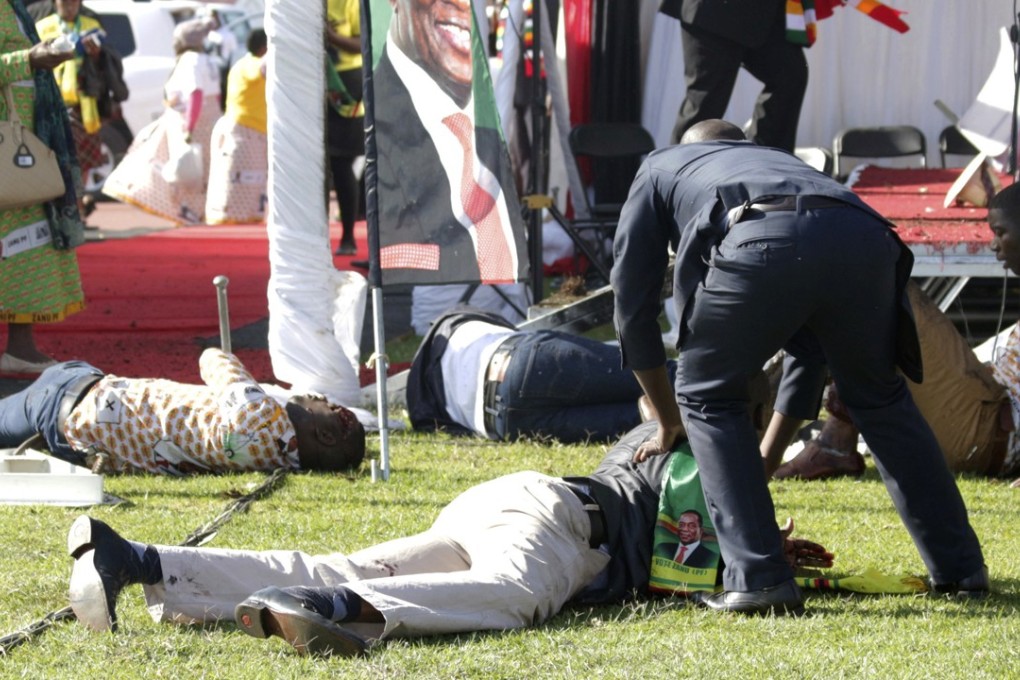 Injured people lay on the ground following an explosion at the ZANU-PF rally in Bulawayo, Zimbabwe. Photo: AFP