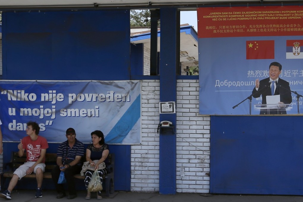 People gather outside the Zelezara Smederevo steel mill in Smederevorest near a hoarding showing Chinese President Xi Jinping and a message that reads “Welcome President”. Photo: AP