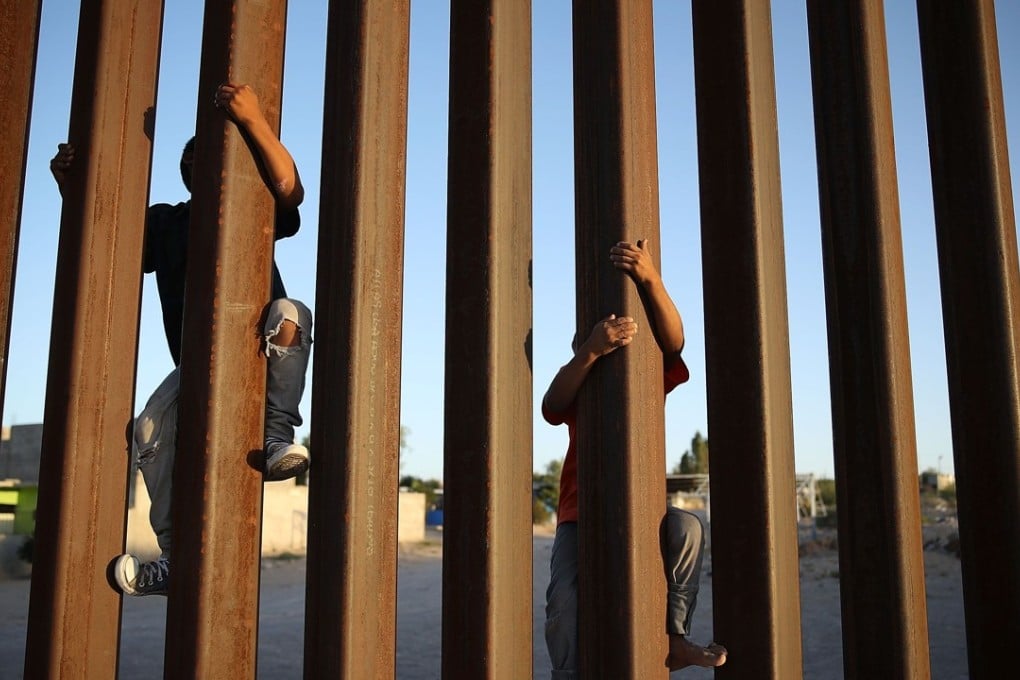 Children climb up the Mexican side of the US-Mexico border fence on June 24 in Sunland Park, New Mexico. Photo: Getty Images / AFP