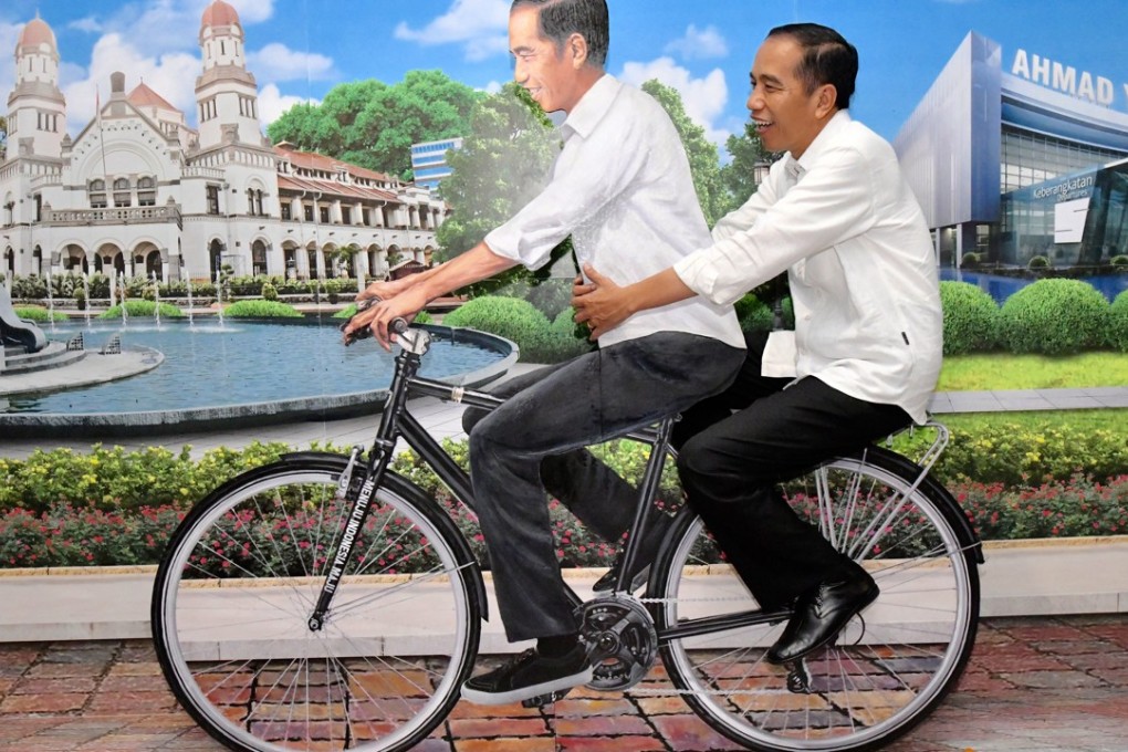 Joko Widodo, posing on a bicycle with a cardboard cut-out of himself, is looking for some big wins in Wednesday’s regional ballots, especially in West Java. Photo: AFP