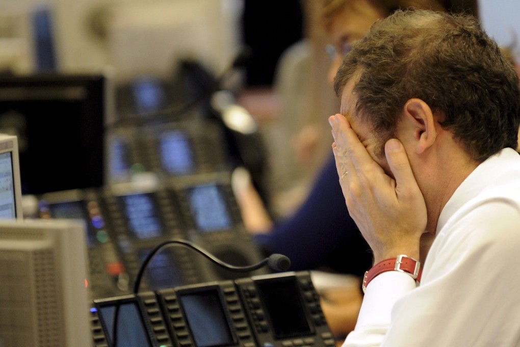 A trader covers his face with his hands at the stock exchange in Milan, Italy, in 2008. Photo: EPA-EFE