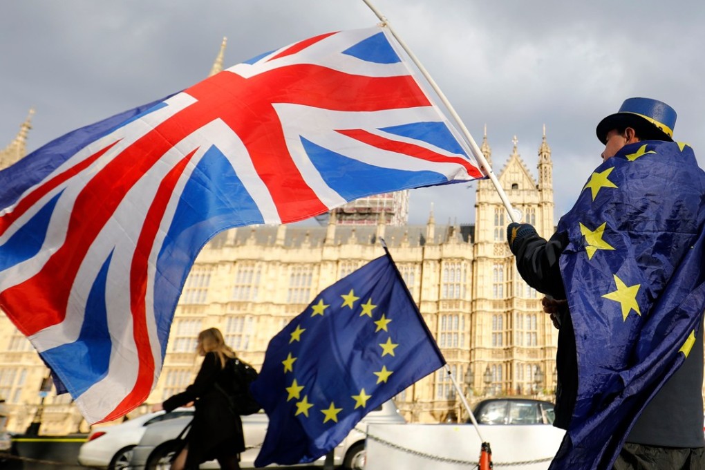 An anti-Brexit demonstrator waves a Union flag alongside a European Union flag outside the Houses of Parliament in London. A bill enacting Britain's decision to leave the European Union has become law after months of debate. Photo: AFP