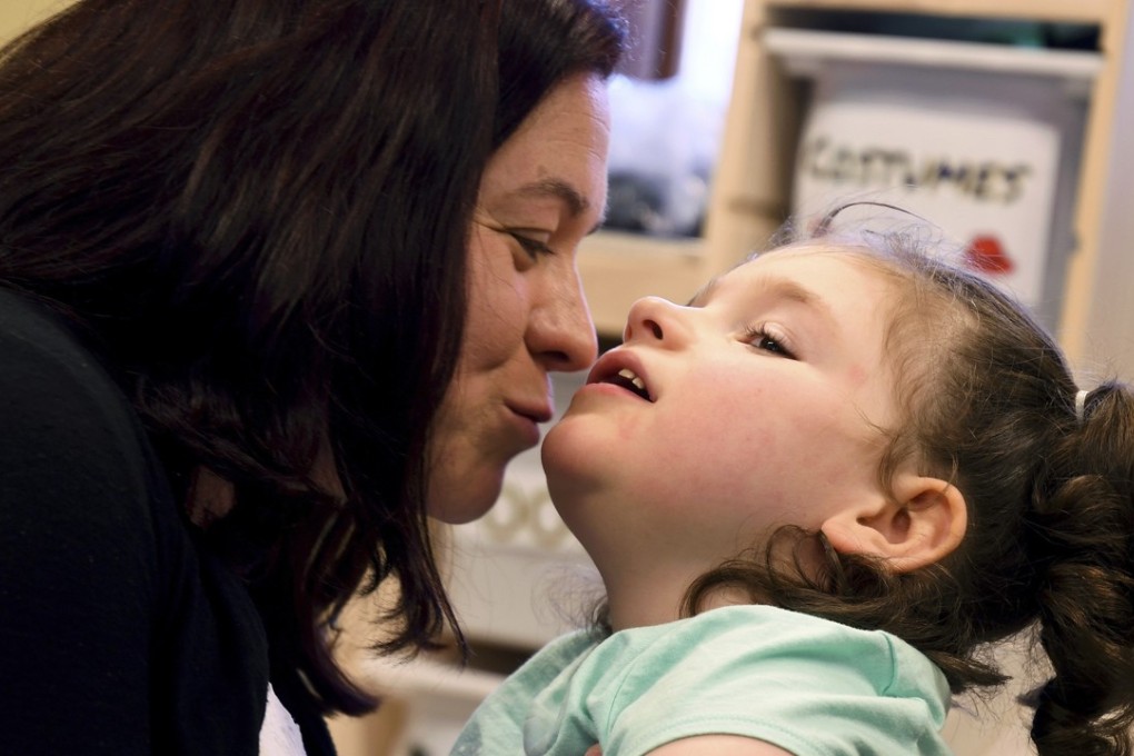 In this April 23, 2018, photo, Meagan Patrick kisses her daughter, Addelyn Patrick, 5, in the playroom at Realm of Caring in Colorado Springs, Colorado. Addelyn was born with a brain malformation and suffers from multiple forms of seizures. Photo: AP