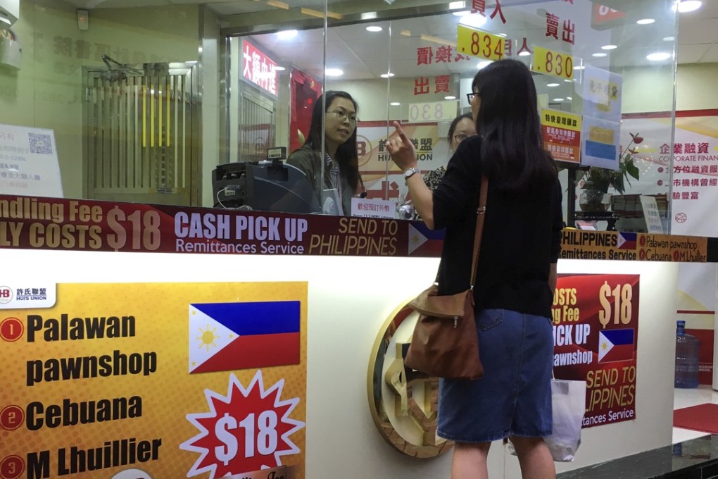 A customer at Hui's Brothers Currency Exchange Group, one of the biggest remittance agents in Hong Kong, which charges a HK$18 fee for each transaction. Photo: Eugene Tang