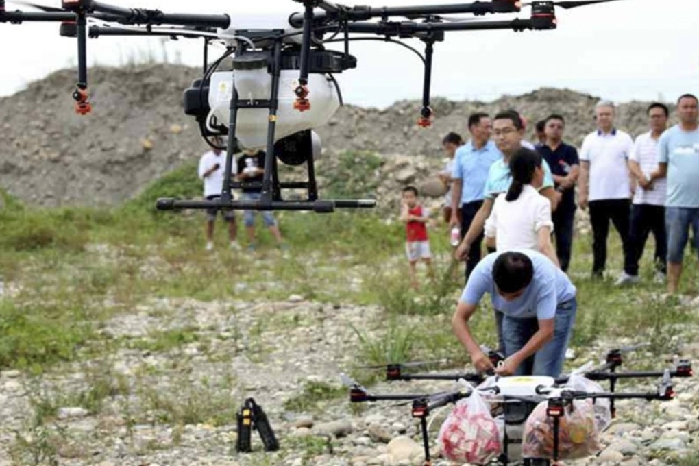 Onlookers watch the drones being loaded with supplies. Photo: scol.com.cn