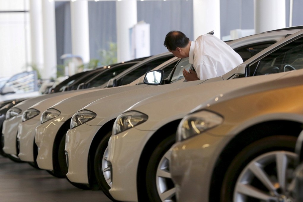 A man looks at second-hand BMW cars at a showroom in Beijing, China, in this September 11, 2015 file photo. BMW retained the title of world's biggest luxury carmaker, annual sales figures released on Monday showed. REUTERS/Kim Kyung-Hoon/Files