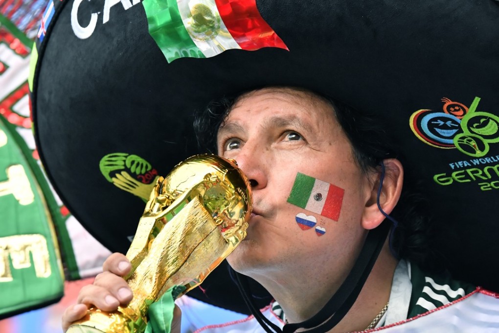 A Mexico fan kisses a replica of the World Cup trophy. Photo: AP