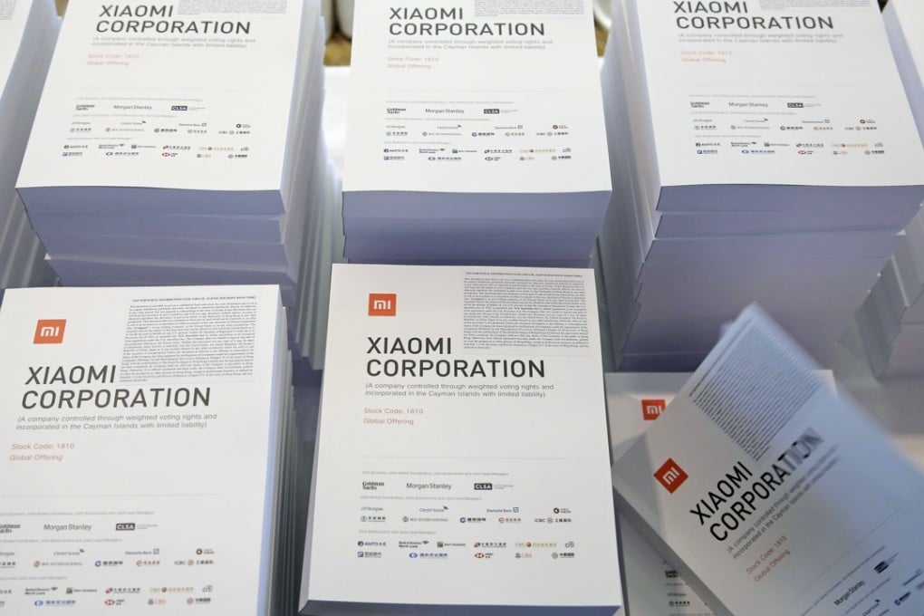 A woman takes a brochure of the initial public offering (IPO) of Xiaomi at a news conference in Hong Kong, Saturday, June 23, 2018. Xiaomi Corp. said it seeks to raise up to $6.1 billion in its initial public offering next week that would value the Chinese smartphone maker at as much as $70.3 billion. (AP Photo/Kin Cheung)