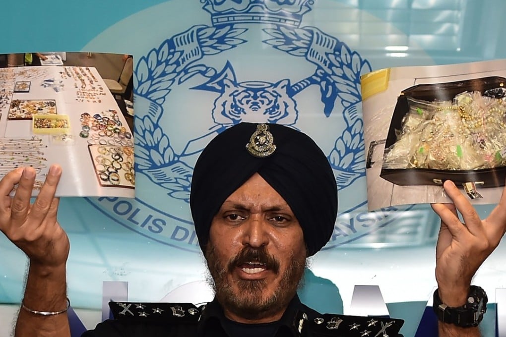 Malaysian Police's Commercial Crime Investigation Department Director Amar Singh shows pictures of items seized from six premises linked to ousted Malaysian leader Najib Razak, including cash, a vast stash of jewellery and luxury handbags, are worth up to US$273 million. Photo: AFP