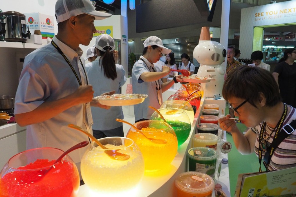 A visitor to a food fair in Taipei tries the desserts on offer, on June 27. With more youngsters leaving for studies and work abroad, concerns have been raised about Taiwan’s long-term economic prospects. Photo: EPA-EFE