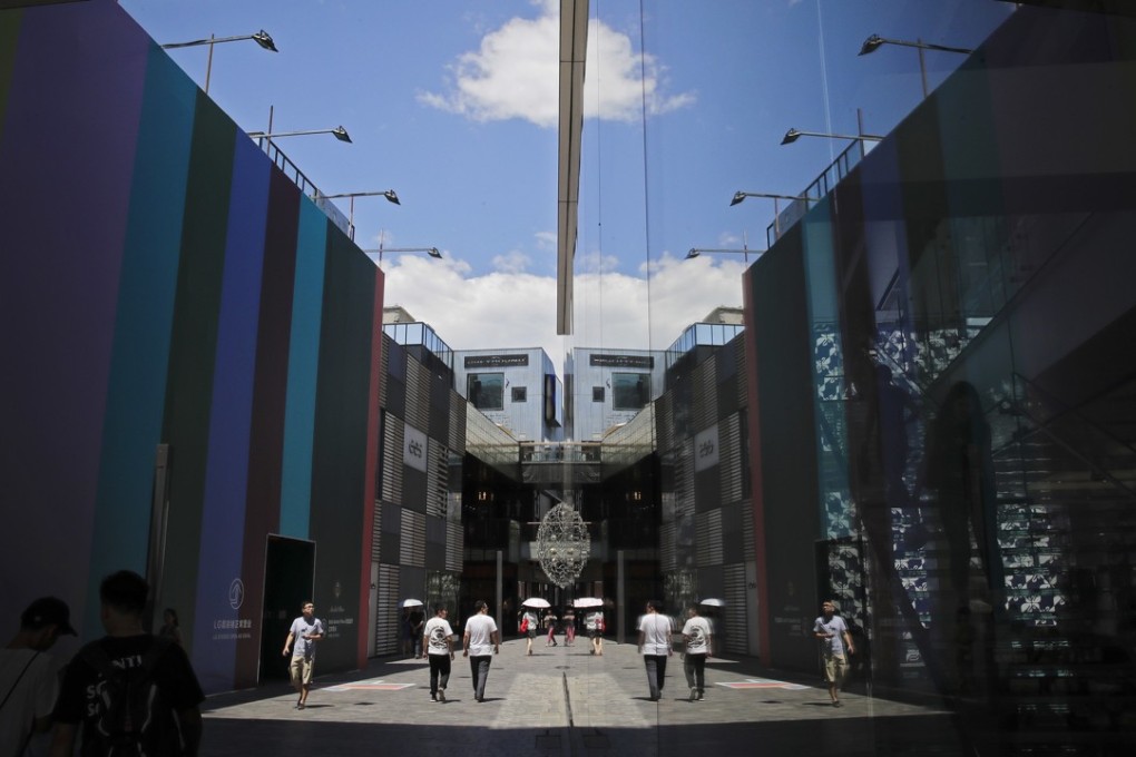 People walking through a popular shopping mall in Beijing are reflected in the glass panels of an Apple Store. The benefits of open, vibrant markets extend well beyond foreign businesses. Yet, China still ranks as one of the most restrictive countries for FDI, according to an OECD report. Photo: AP