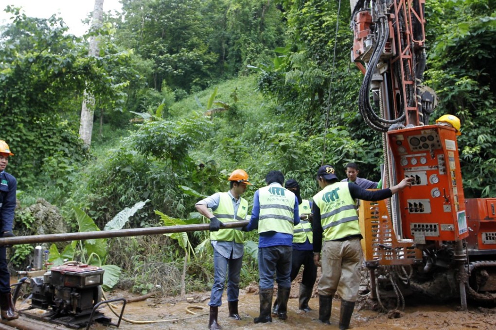 Thai workers use drilling machinery equipment in an attempt to drain the water from the flooded cave. Photo: EPA