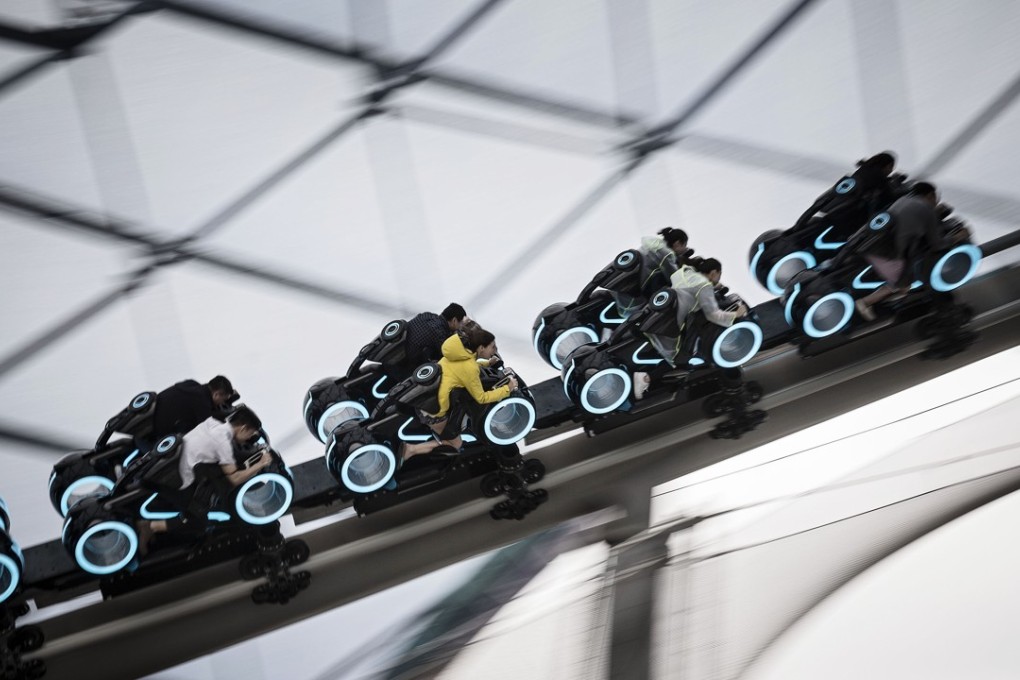 Visitors ride a roller coaster during a trial run at Shanghai Disneyland on June 8. Loose central bank monetary policies fuelled a rush to emerging markets for higher returns, but the investment climate is changing. Photo: Bloomberg
