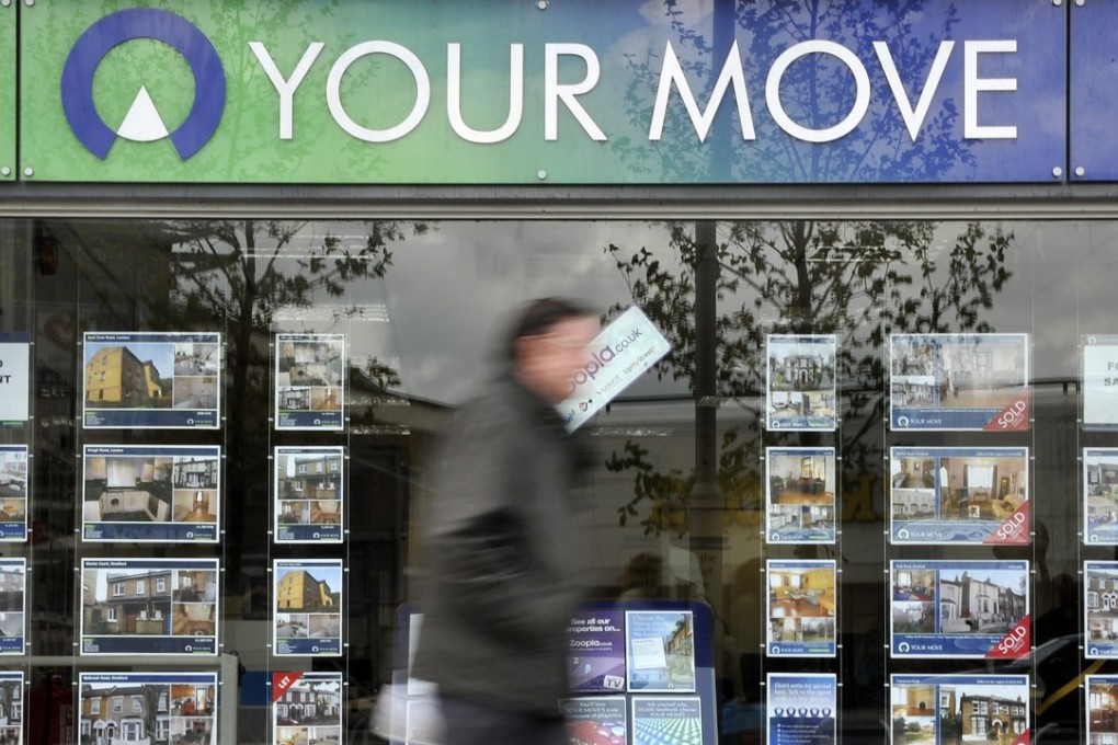 A pedestrian walks past an estate agent in London. Photo: EPA