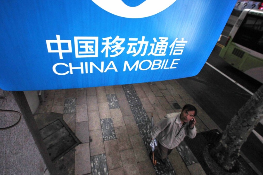 A man walks past a China Mobile sign in downtown Shanghai, China. Photo: Reuters