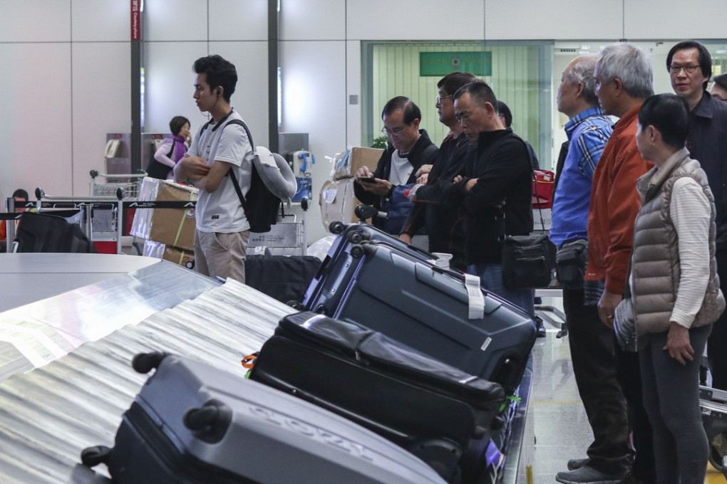 Travellers wait for their luggage to arrive on a conveyor belt at the Hong Kong International Airport. Photo: Roy Issa