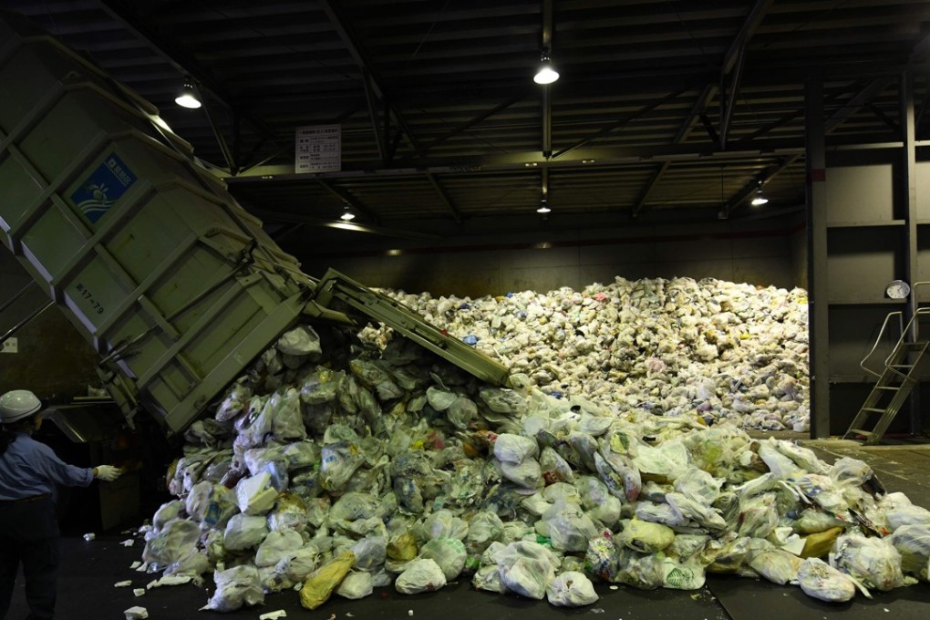 Workers unload plastic recyclable resources from Tokyo's Katsushika city, at the Ichikawa Kankyo Engineering recycling centre in Narashino, Chiba prefecture. The government is scrambling to boost recycling resources as China limits plastic waste imports. Photo: AFP