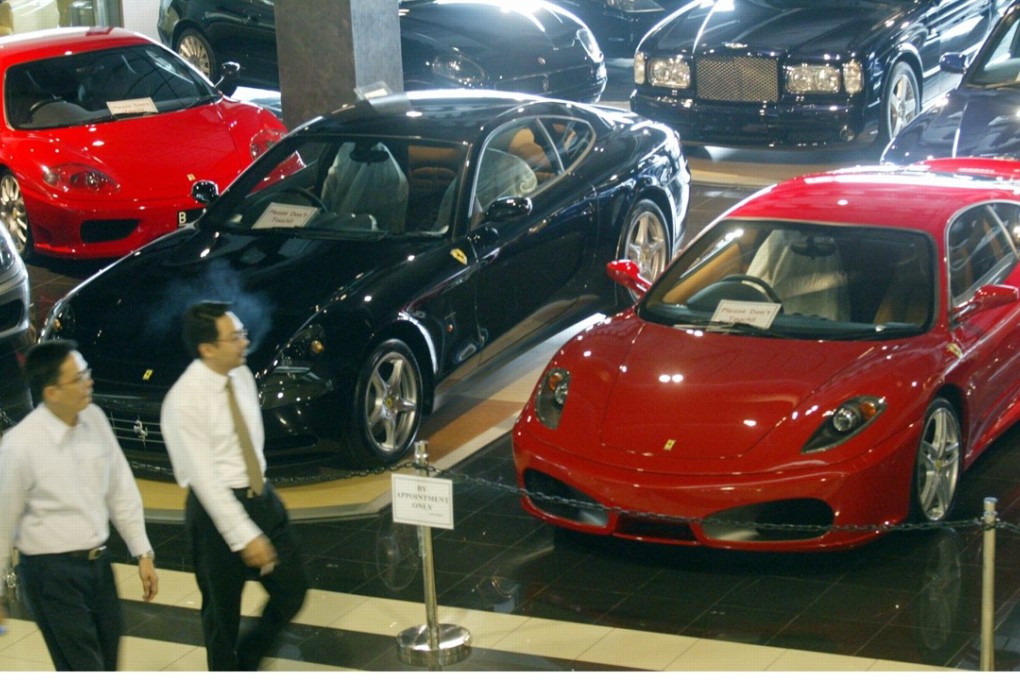 Indonesian customers visit a car mall in Jakarta. Men use luxury brands in the same way that animals use antlers, scientists say – and testosterone plays a role. Photo: Reuters