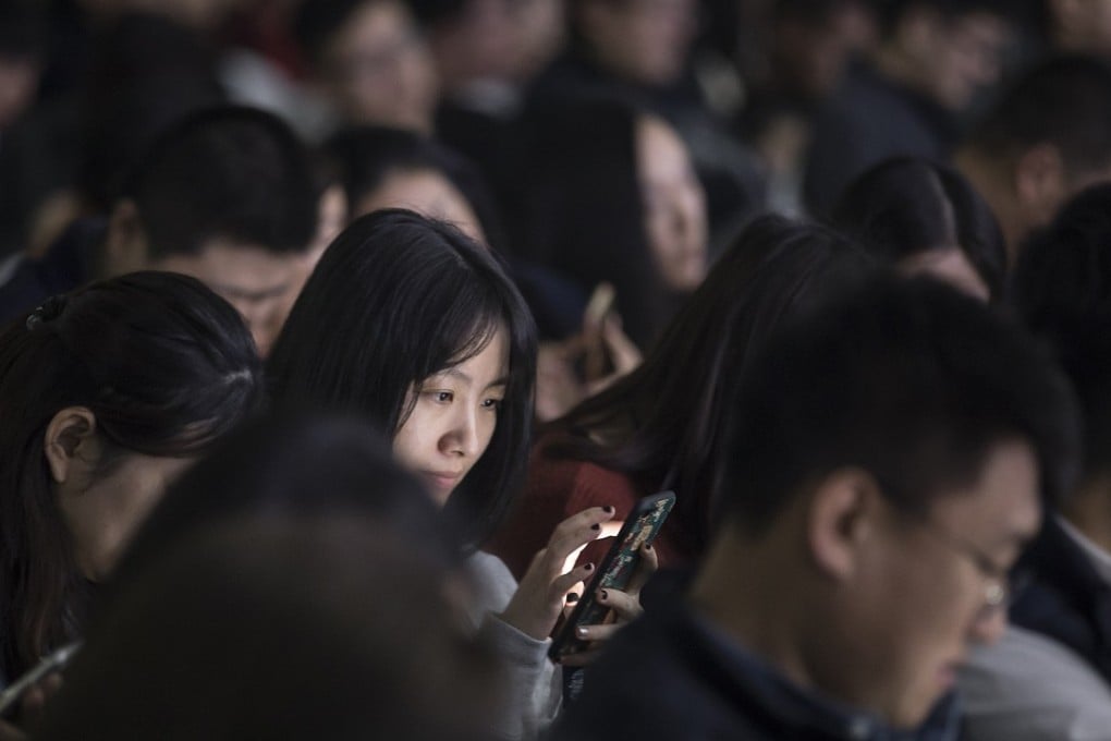 An attendee uses her smartphone during Tencent Holdings Ltd.'s WeChat Open Class Pro conference in Guangzhou, China, on Monday, Jan. 15, 2018. WeChat, the social network that is nearly ubiquitous in China, said at the conference that it has 580,000 mini-programs in operation. Photographer: Qilai Shen/Bloomberg