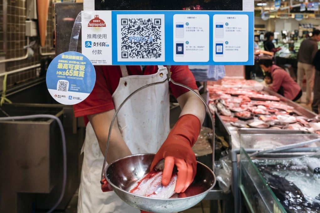 Payment instructions for Alipay at a fish stall inside a market in Hong Kong. Online payment providers face resistance in Hong Kong as customers prefer more traditional methods. Photo: Bloomberg