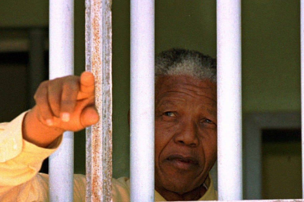 In 1994, four years after his release, Nelson Mandela stares out of the window of the prison cell he occupied on Robben Island. Photo: Reuters.
