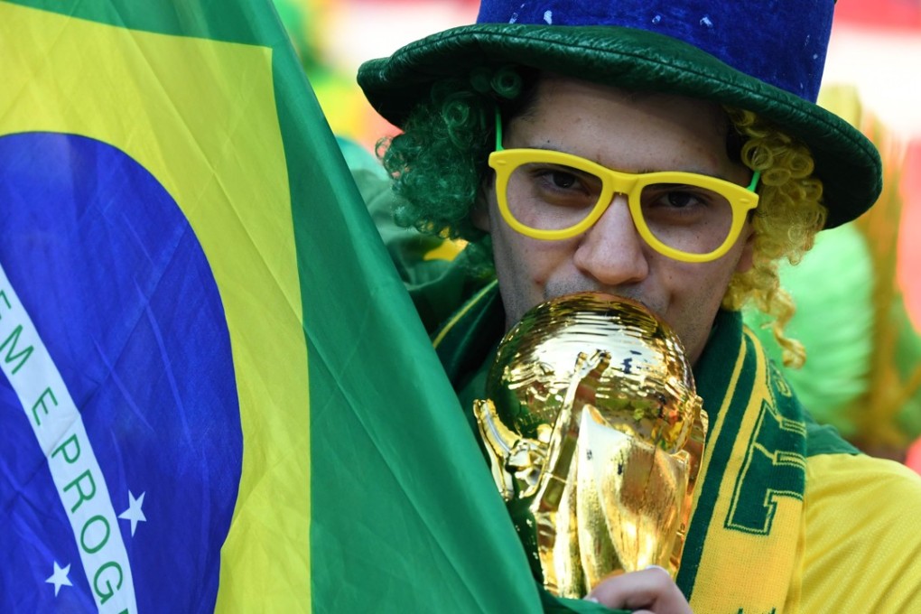 A Brazilian fan kisses a replica of the World Cup trophy. Photo: AFP