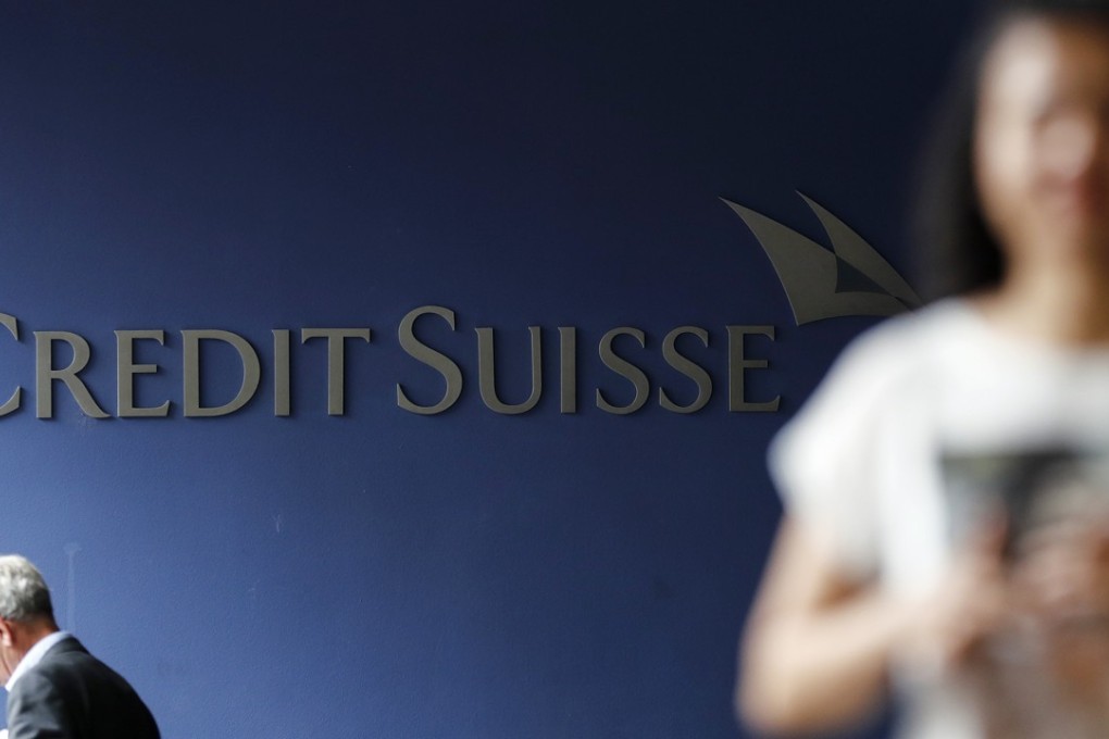 Pedestrians walk by a sign outside a Credit Suisse Group AG office building in Bern, Switzerland, on June 6. Photo: Bloomberg