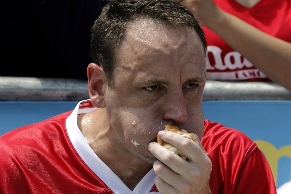 Champion eater Joey Chestnut swallows hot dogs on his way to victory at the Nathan's Famous Fourth of July International hot dog eating contest at Coney Island, New York. Photo: EPA