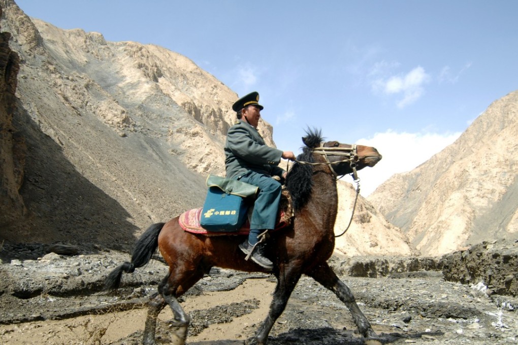 A postman goes on his rounds in the Pamir Mountains in the remote western region of China, serving more than 5,000 nomads across 2,200 sq km, in March 2012. The Universal Service Obligation strives to ensure that everyone has access to postal services. Photo: Xinhua
